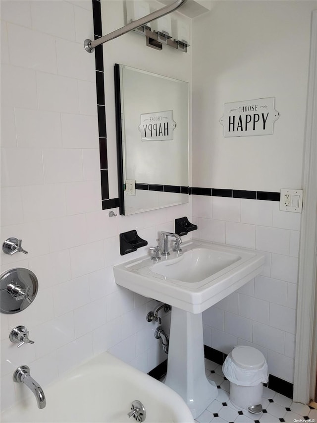 bathroom with tile patterned floors and tile walls