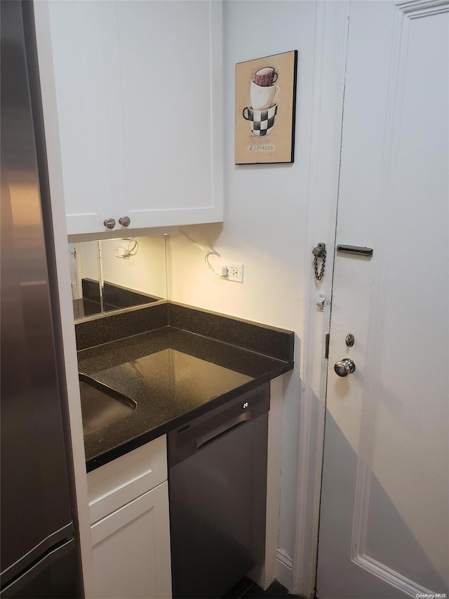 434 E 52nd St Unit 9A, New York Manhattan, NY 10022 - kitchen featuring dishwashing machine, white cabinetry, stainless steel refrigerator, and dark stone counters