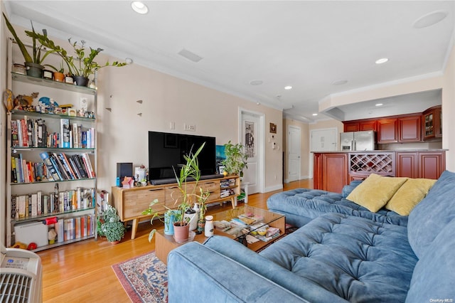 living room featuring light wood-type flooring and crown molding