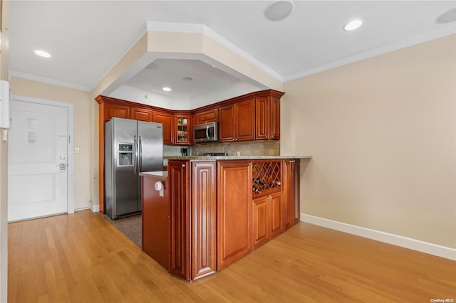 kitchen with kitchen peninsula, appliances with stainless steel finishes, light wood-type flooring, decorative backsplash, and ornamental molding