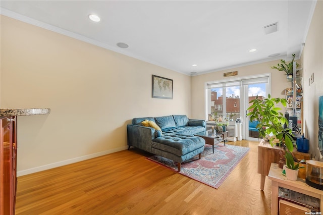 living room featuring ornamental molding and light wood-type flooring