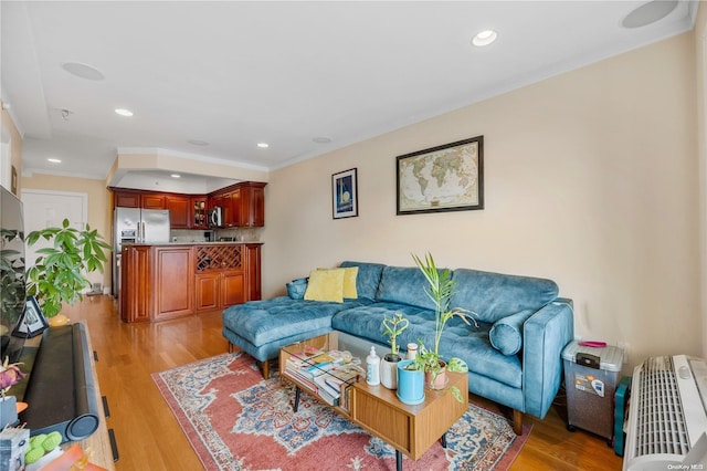 living room with light wood-type flooring and ornamental molding