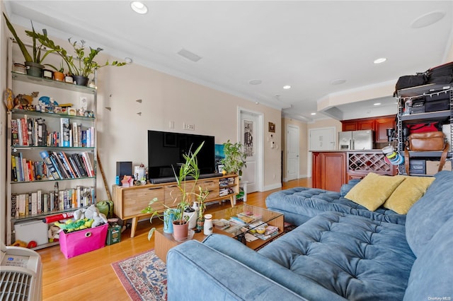 living room with light wood-type flooring and ornamental molding