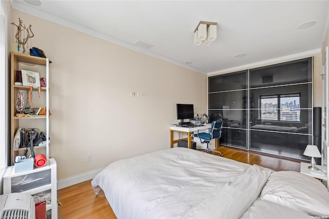 bedroom featuring crown molding and hardwood / wood-style flooring