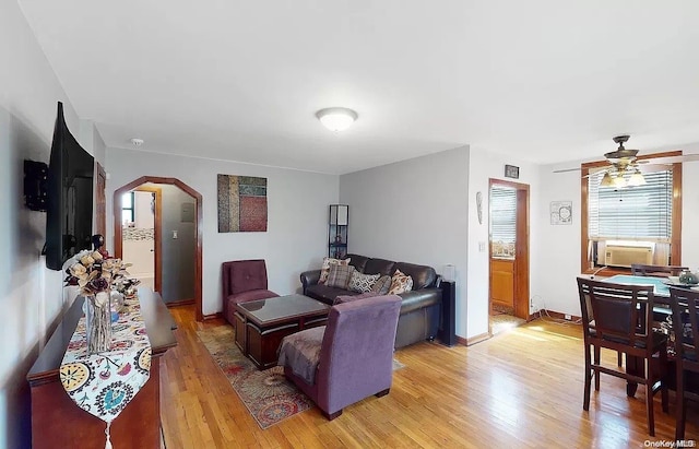 living room featuring light hardwood / wood-style floors, ceiling fan, and cooling unit