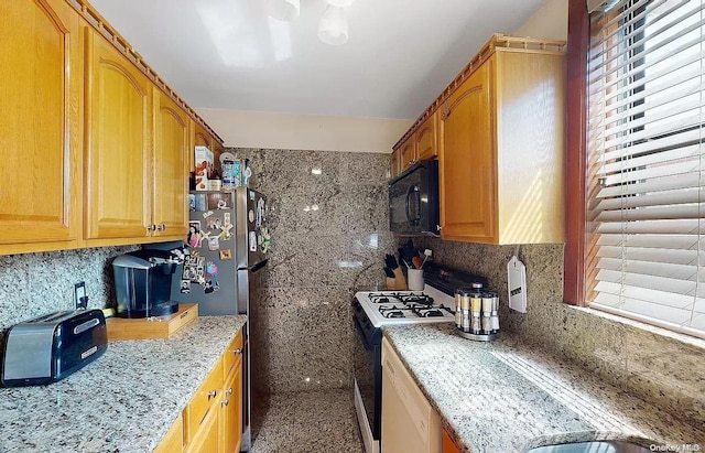 kitchen featuring light stone countertops, white appliances, and backsplash