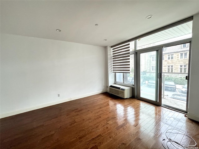 interior space with a wall mounted AC and hardwood / wood-style flooring