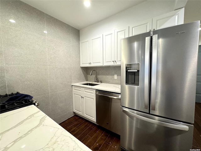 kitchen featuring dark hardwood / wood-style flooring, light stone countertops, sink, and appliances with stainless steel finishes