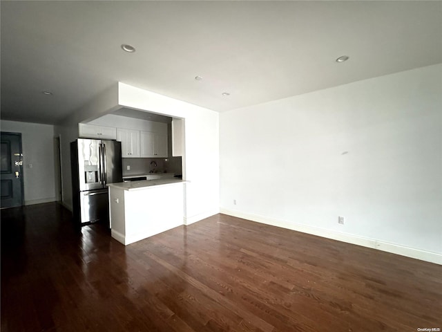 kitchen featuring white cabinets, sink, stainless steel refrigerator with ice dispenser, dark hardwood / wood-style floors, and kitchen peninsula