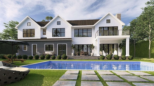 back of house featuring a yard, a patio area, and a balcony