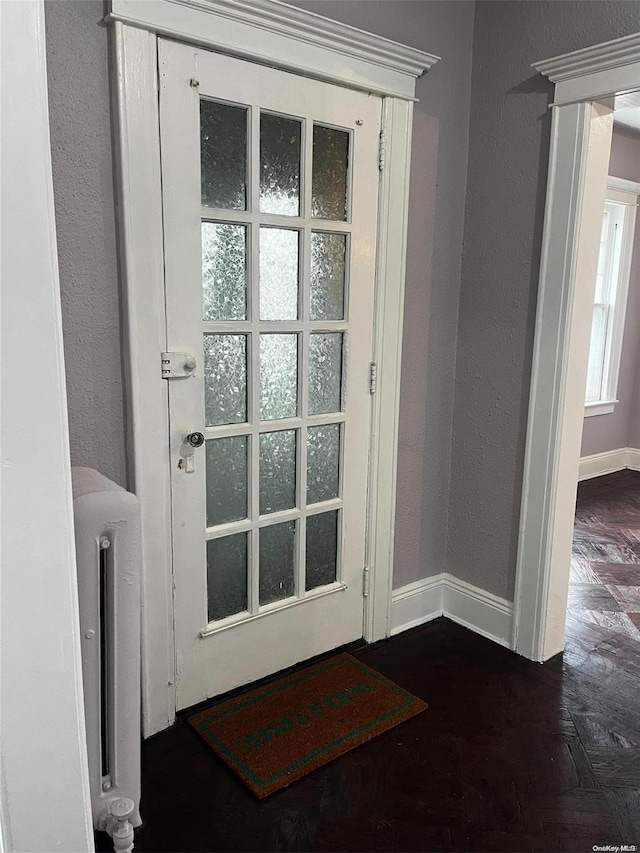 entryway featuring dark parquet flooring and radiator heating unit