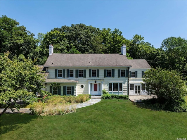 colonial inspired home with a front yard and french doors