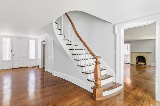 foyer entrance featuring a premium fireplace and hardwood / wood-style flooring