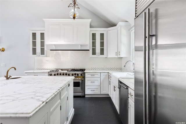 kitchen with tasteful backsplash, vaulted ceiling, sink, high quality appliances, and white cabinets