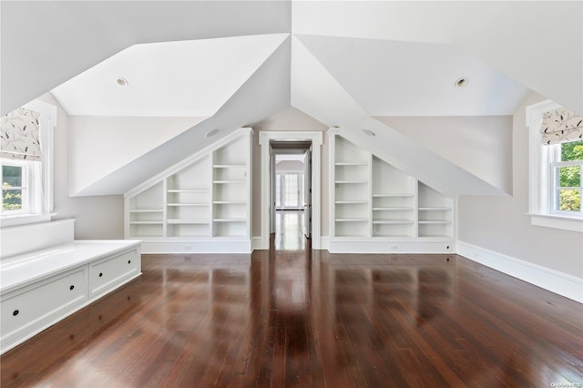 bonus room with dark hardwood / wood-style floors, built in features, and lofted ceiling