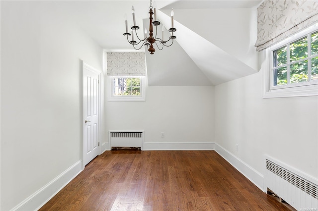 additional living space with dark hardwood / wood-style flooring, an inviting chandelier, radiator, and lofted ceiling