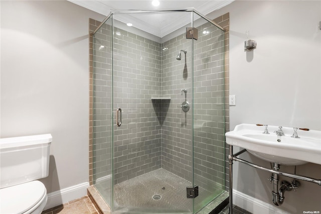 bathroom with crown molding, a shower with door, and toilet