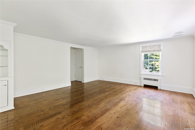 empty room with radiator, dark hardwood / wood-style floors, and ornamental molding