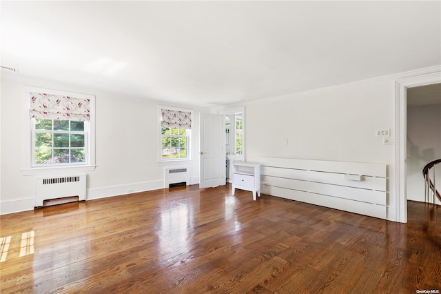 interior space featuring wood-type flooring, crown molding, and radiator