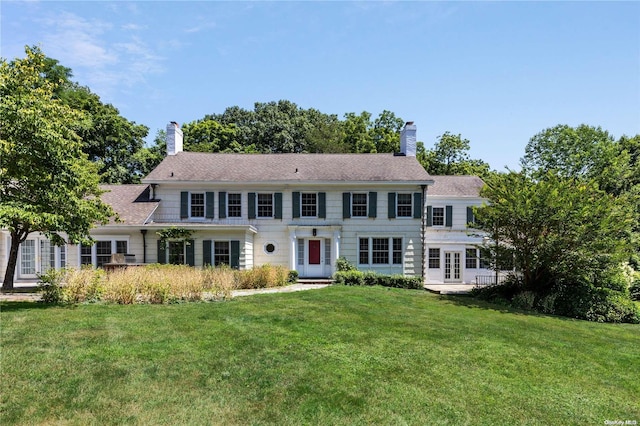 colonial-style house featuring french doors and a front lawn