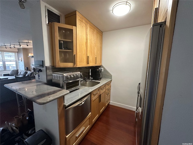 kitchen featuring light stone countertops, sink, dark hardwood / wood-style floors, kitchen peninsula, and a breakfast bar