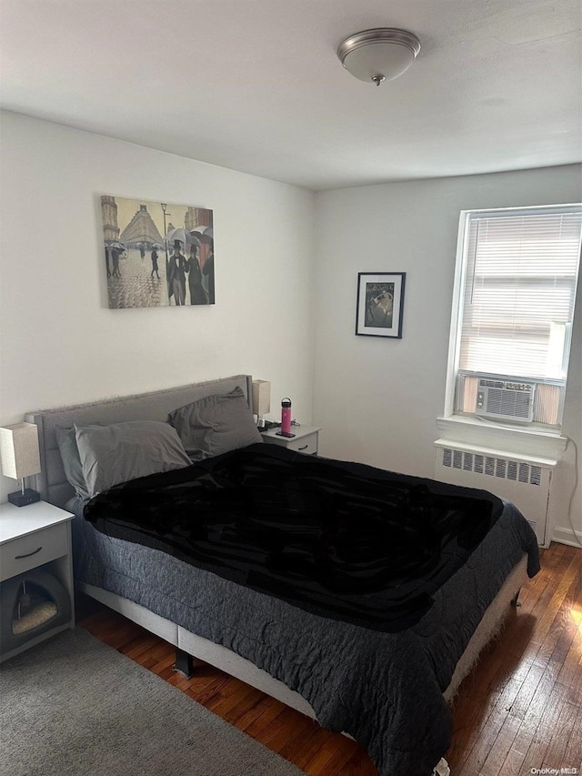 bedroom featuring radiator, cooling unit, and dark hardwood / wood-style floors