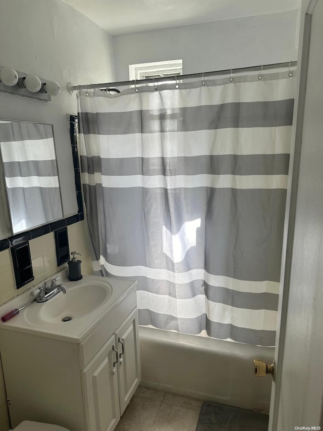 bathroom with tile patterned flooring, vanity, tasteful backsplash, and shower / tub combo with curtain