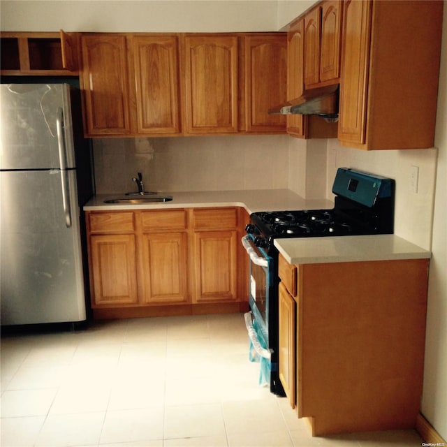 kitchen featuring stainless steel fridge, stove, tasteful backsplash, sink, and light tile patterned flooring