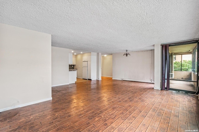 unfurnished living room with wood-type flooring, a textured ceiling, and a baseboard heating unit