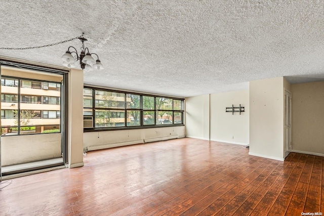 unfurnished living room with hardwood / wood-style floors, a baseboard radiator, a chandelier, and a textured ceiling