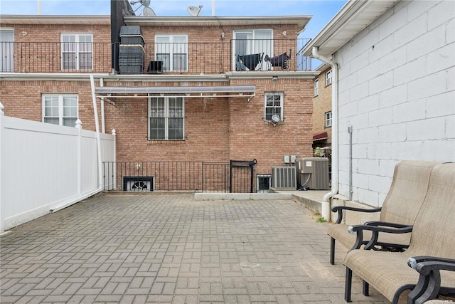 rear view of property with central air condition unit and a patio