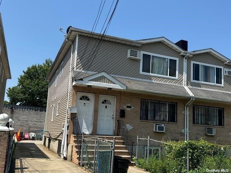 view of front of house with a wall mounted AC