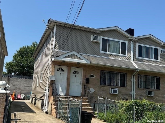 view of front of house with a wall mounted AC