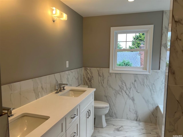 bathroom featuring vanity, tile walls, and toilet