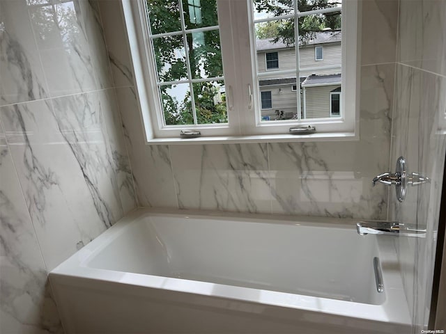 bathroom with a bathing tub and plenty of natural light