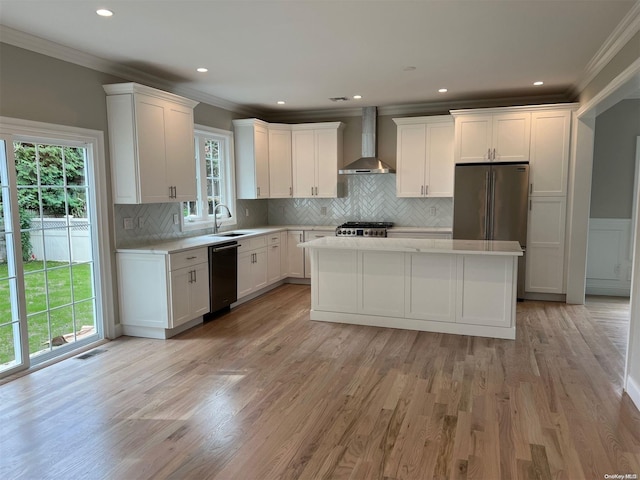 kitchen featuring white cabinets, dishwasher, wall chimney range hood, and sink