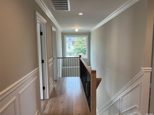 corridor featuring light wood-type flooring and crown molding