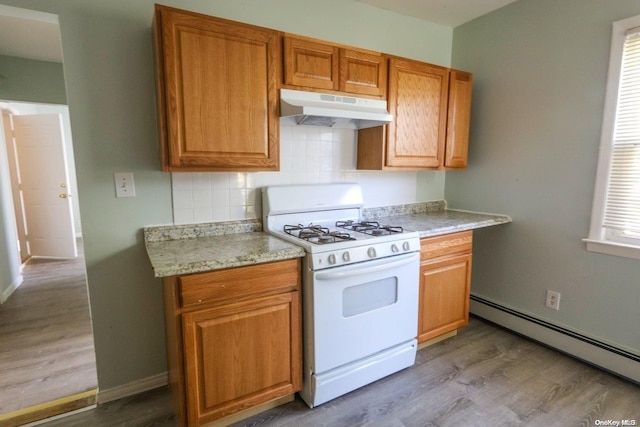 kitchen featuring decorative backsplash, hardwood / wood-style floors, a baseboard radiator, and white gas range oven