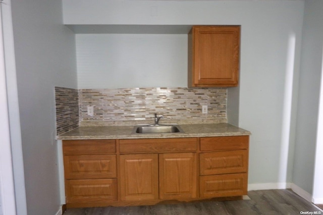 kitchen with dark hardwood / wood-style flooring, backsplash, and sink