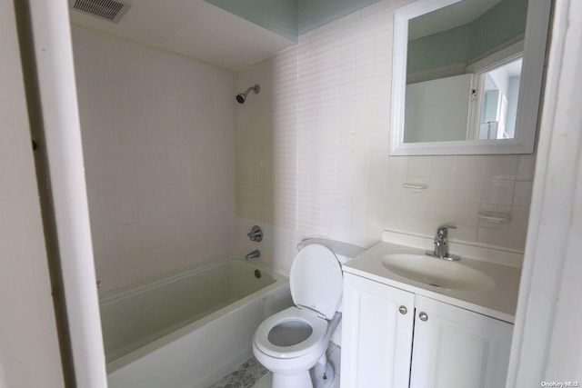 full bathroom featuring backsplash, toilet, vanity, tile walls, and tiled shower / bath