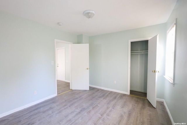 unfurnished bedroom featuring a closet and light hardwood / wood-style flooring