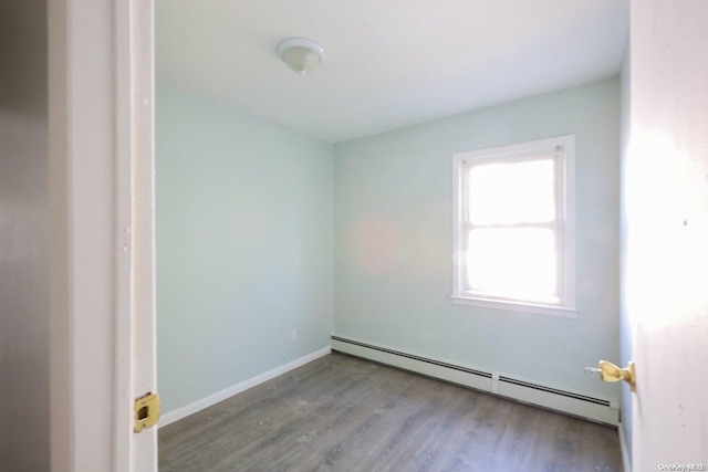 spare room featuring light wood-type flooring and a baseboard heating unit