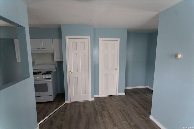 kitchen with white cabinets, white gas range oven, and dark hardwood / wood-style floors