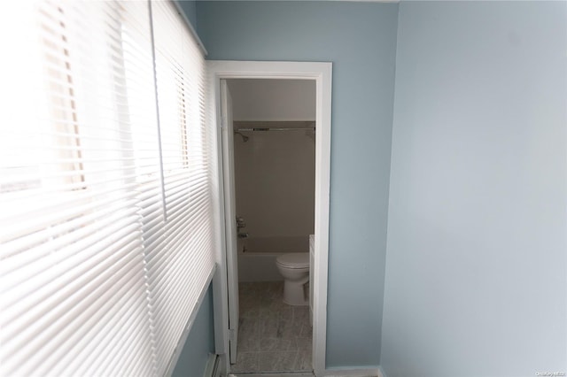 bathroom featuring a washtub, tile patterned floors, and toilet