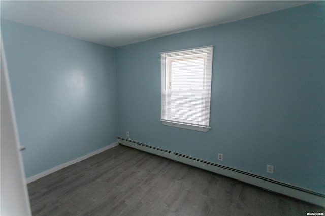 spare room featuring hardwood / wood-style floors and a baseboard radiator