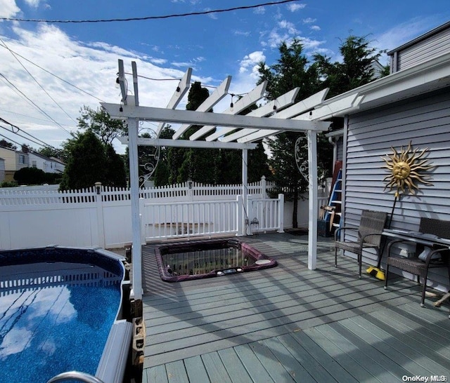 deck featuring a pergola and a pool with hot tub