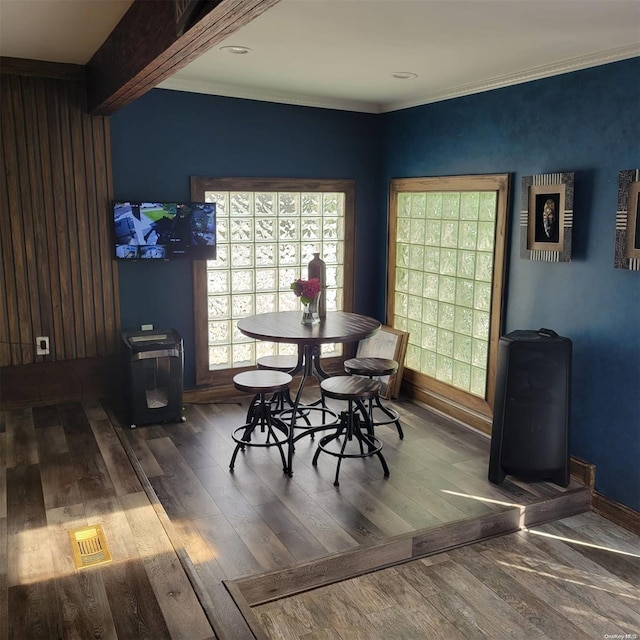 dining area with wood-type flooring and crown molding