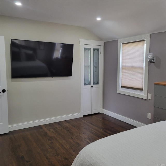 bedroom featuring dark hardwood / wood-style flooring and lofted ceiling