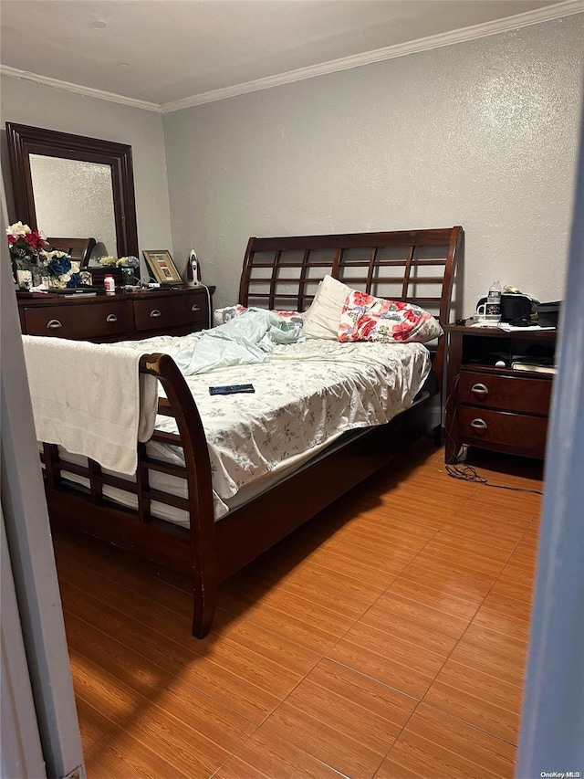 bedroom with wood-type flooring and ornamental molding