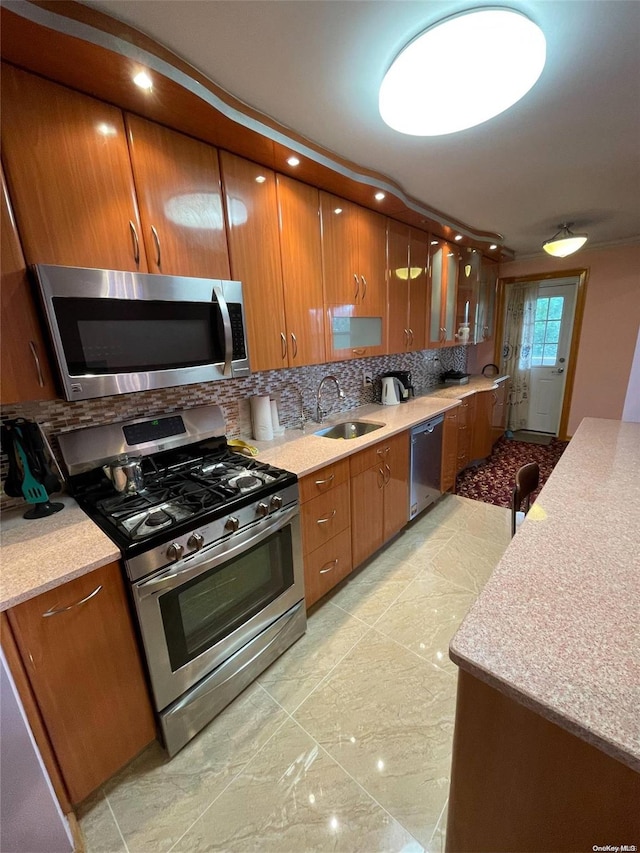 kitchen with decorative backsplash, appliances with stainless steel finishes, and sink